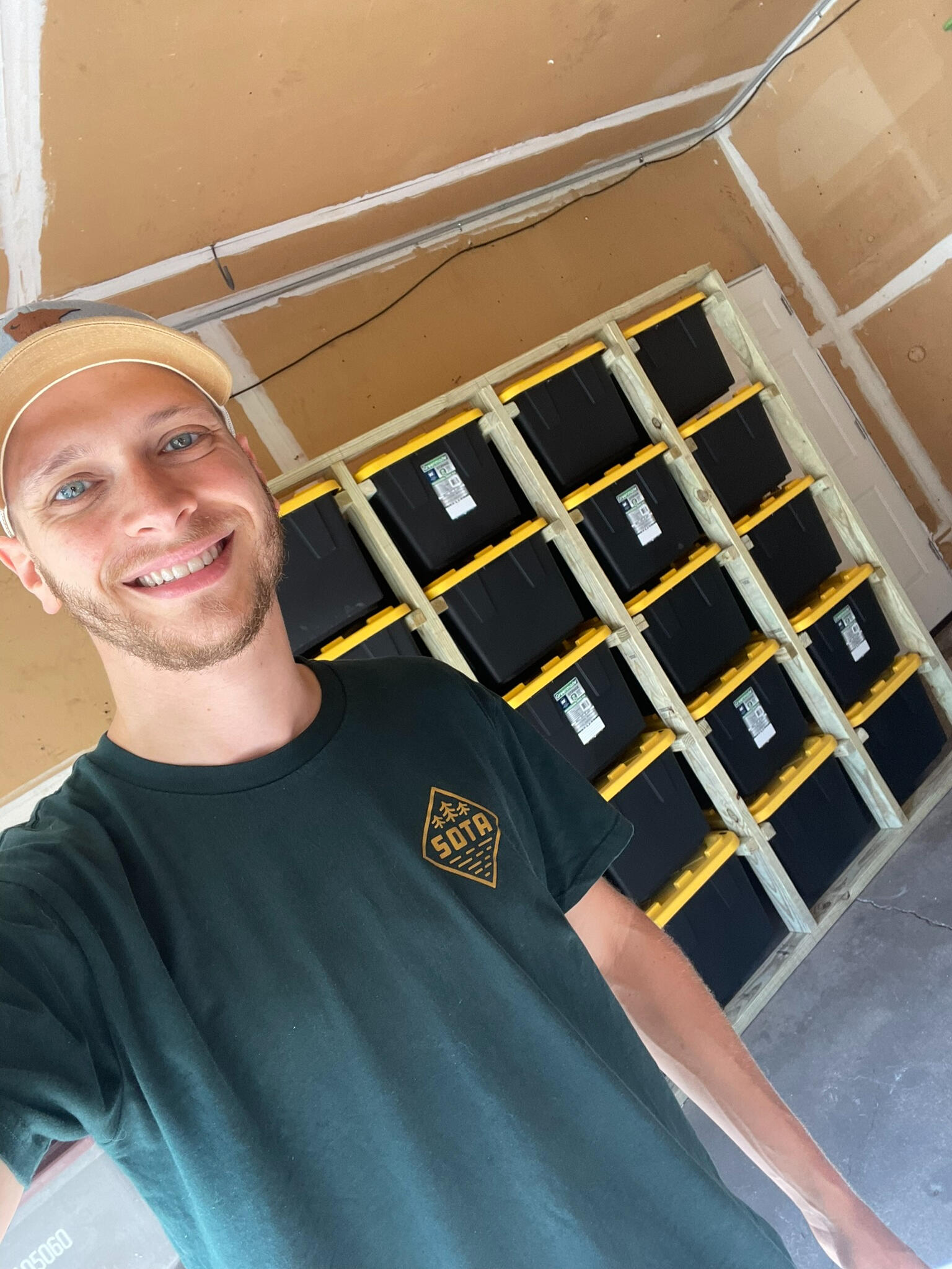 Dan Goldstein Intro An image of a man named Dan who is wearing a green short and a yellow baseball hat. He is standing in front of a wooden storage unit and smiling.